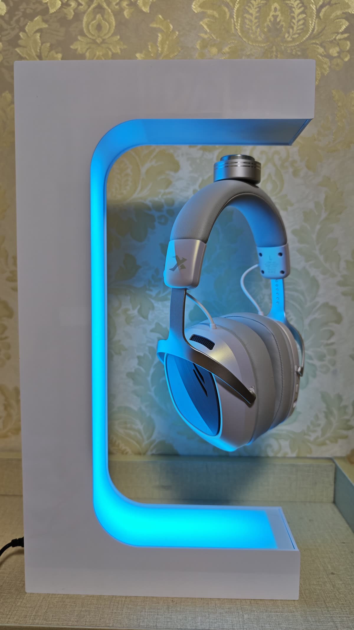 Real user setup photo of Beacon 01 glowing blue with a headset